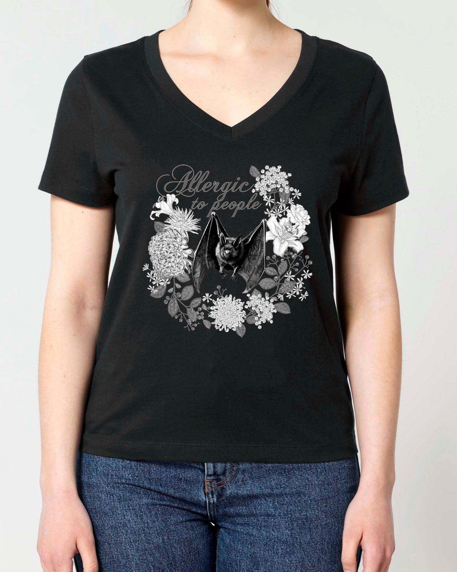 A woman modeling a black V-neck t-shirt with a Vintage style monochrome graphic print of a bat and flowers.